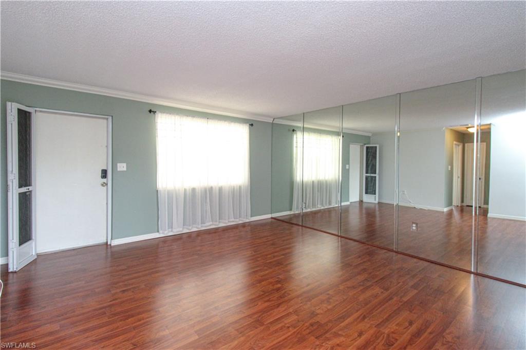 729 Palm View Drive, Unit D4 Naples, FL 34110 - Photo 8 of 23 a view of wooden floor and windows in an empty room