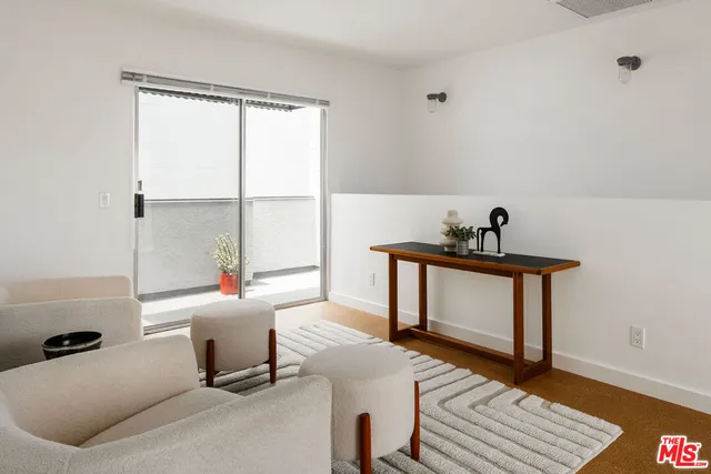 a living room with furniture a window and a potted plant