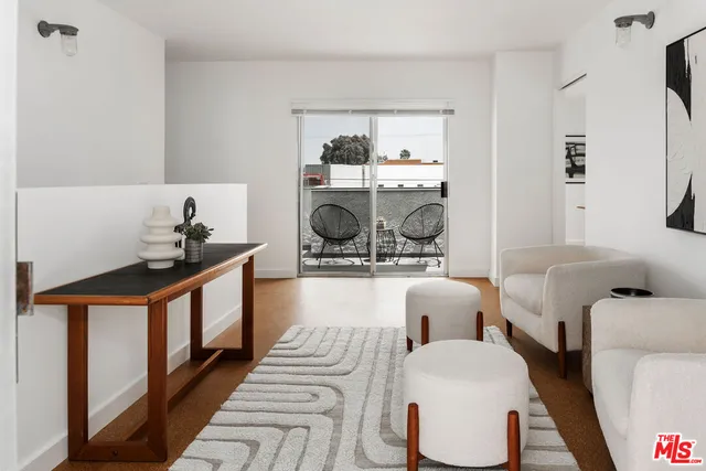 a living room with furniture a rug and white walls