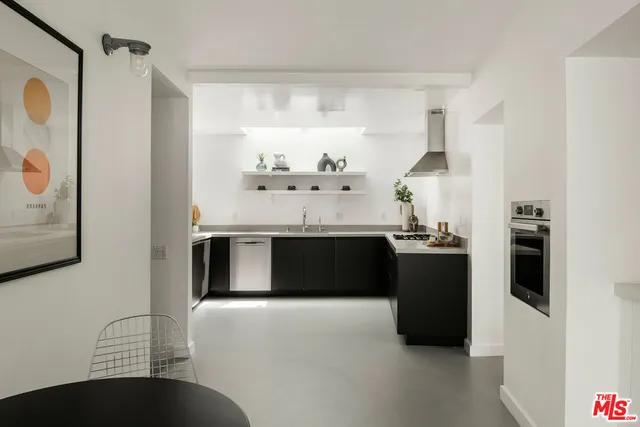 a kitchen with stainless steel appliances kitchen island granite countertop a refrigerator a sink and a stove