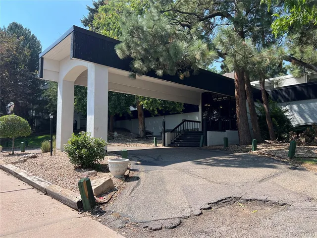 a patio with a table and chairs and potted plants