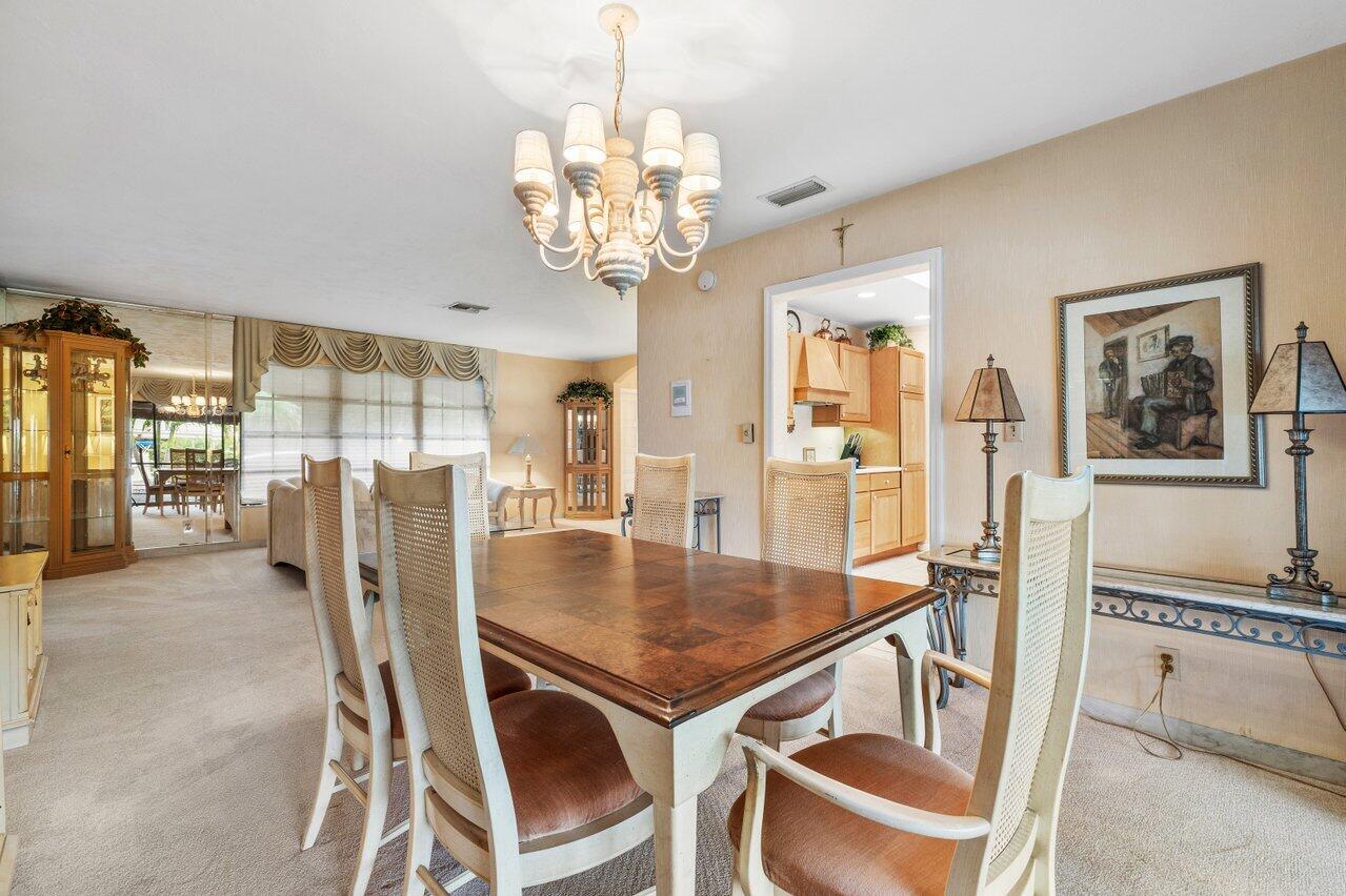 3163 Northeast 8th Avenue Boca Raton, FL 33431 - Photo 13 of 31 a view of a dining room with furniture wooden floor and chandelier