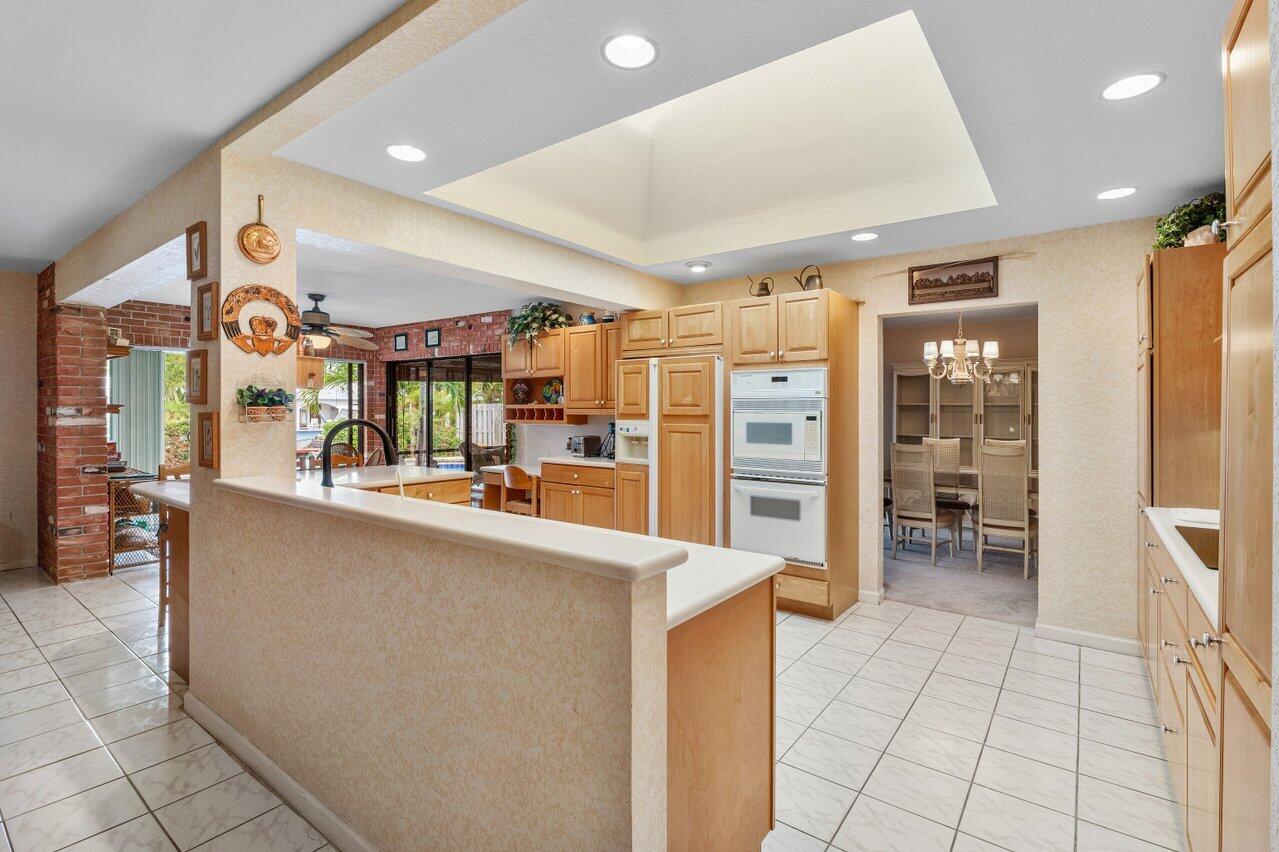 3163 Northeast 8th Avenue Boca Raton, FL 33431 - Photo 15 of 31 a kitchen with stainless steel appliances kitchen island granite countertop a refrigerator and a sink