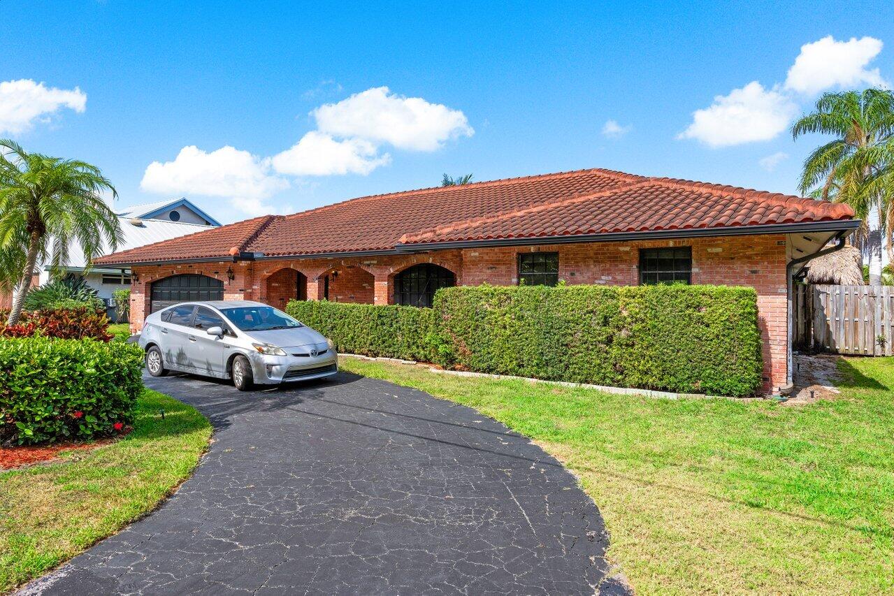 3163 Northeast 8th Avenue Boca Raton, FL 33431 - Photo 8 of 31 a front view of a house with garden