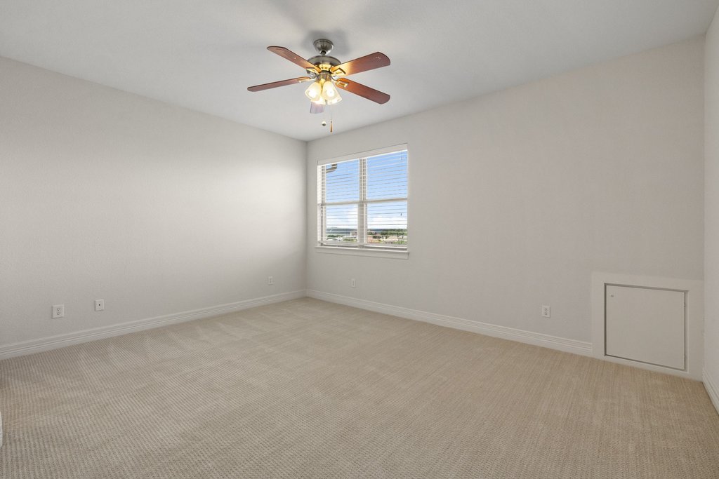 109 Largo Cove Austin, TX 78734 - Photo 23 of 40 A well-lit bedroom with soft carpeting and a ceiling fan, offering a pleasant view.