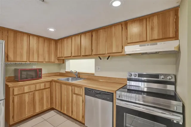 a kitchen with stainless steel appliances granite countertop a sink stove and cabinets