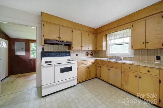 a kitchen with granite countertop white cabinets and white appliances
