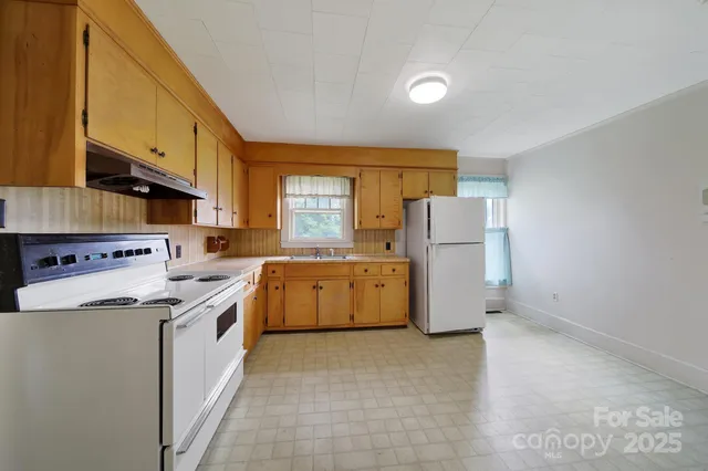 a kitchen with a stove a refrigerator and a sink
