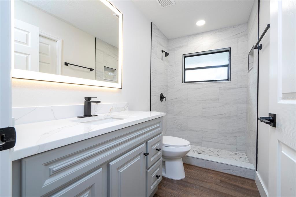 1124 Munster Street Orlando, FL 32803 - Photo 22 of 64 a bathroom with a sink a toilet and shower