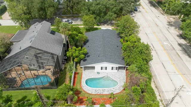 an aerial view of a house with outdoor space pool seating area and yard