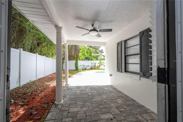 a view of a porch with a floor to ceiling window and garden