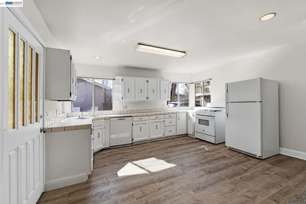 a kitchen with white cabinets and white appliances