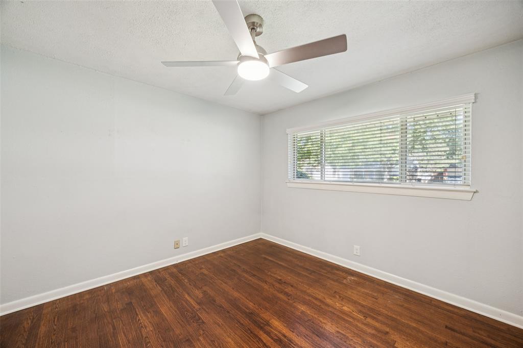 601 Ridgedale Drive Richardson, TX 75080 - Photo 13 of 26 an empty room with wooden floor and windows