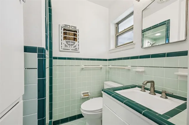 a bathroom with a sink a toilet and mirror