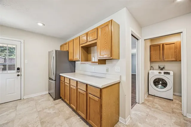 a utility room with cabinets washer and dryer