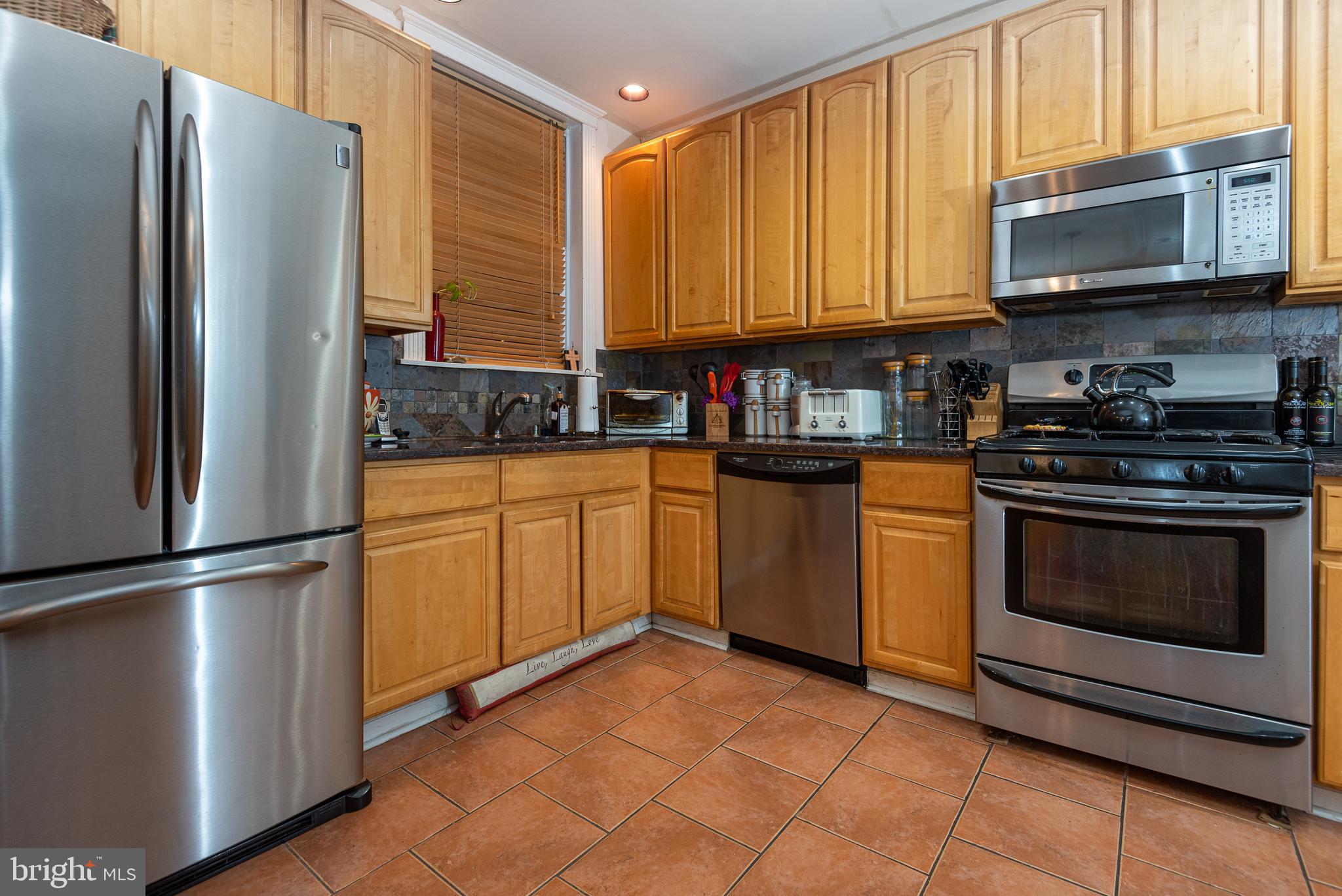426 Glen Echo Road Philadelphia, PA 19119 - Photo 37 of 77 a kitchen with stainless steel appliances granite countertop a stove a refrigerator and a microwave