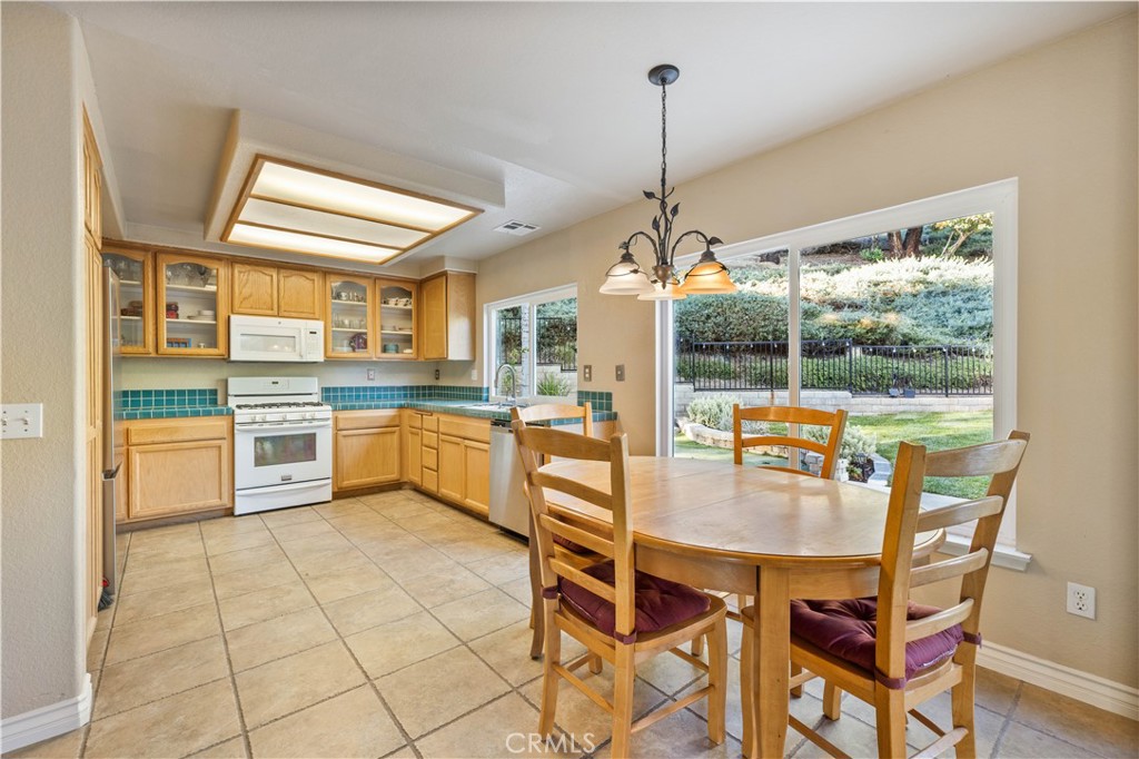 27729 Villa Canyon Road Castaic, CA 91384 - Photo 18 of 72 a kitchen with stainless steel appliances granite countertop a stove top oven a sink dishwasher and white cabinets next to a window