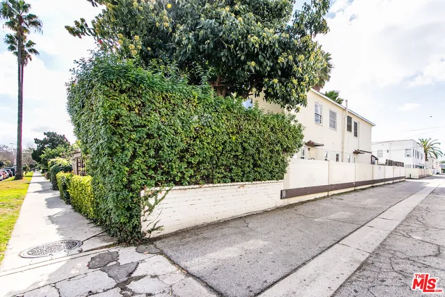 a white house that has a tree on the side of it