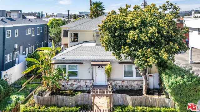 a view of a house with brick walls and flower plants