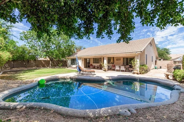 a view of house with swimming pool and yard