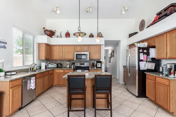 a kitchen with stainless steel appliances granite countertop a stove top oven a sink dishwasher and a refrigerator