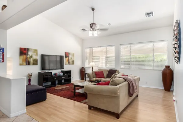 a living room with furniture a flat screen tv and a large window