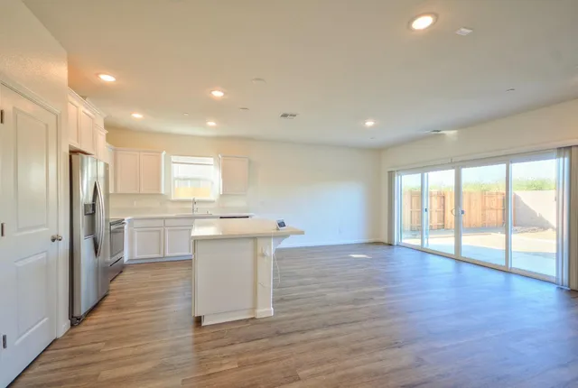 a kitchen with stainless steel appliances granite countertop a sink stove and wooden floor