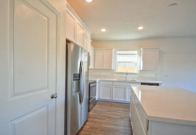 a kitchen with a sink stove and refrigerator