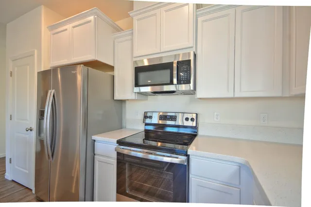 a kitchen with stainless steel appliances a refrigerator stove and microwave