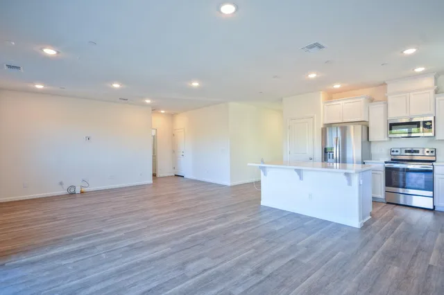a view of kitchen with stainless steel appliances refrigerator microwave and stove