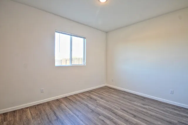 wooden floor in an empty room with a window