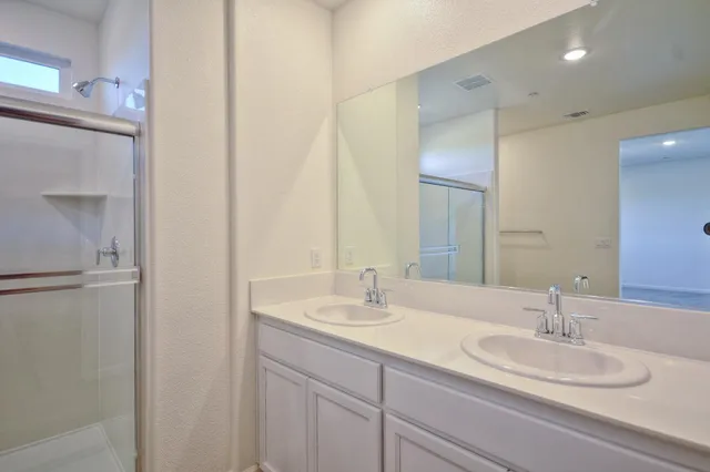 a bathroom with a double vanity sink and a mirror