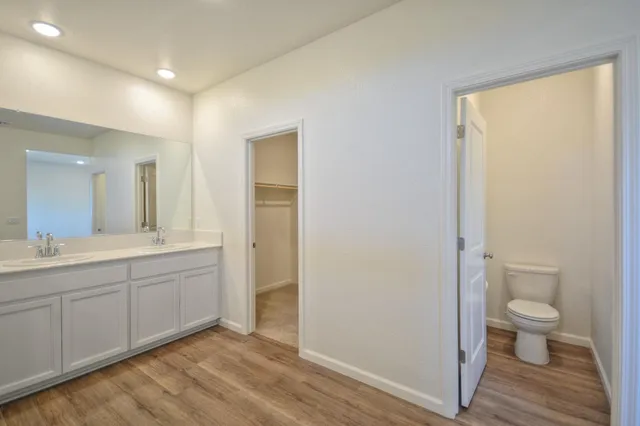 a spacious bathroom with a granite countertop sink a toilet and a shower