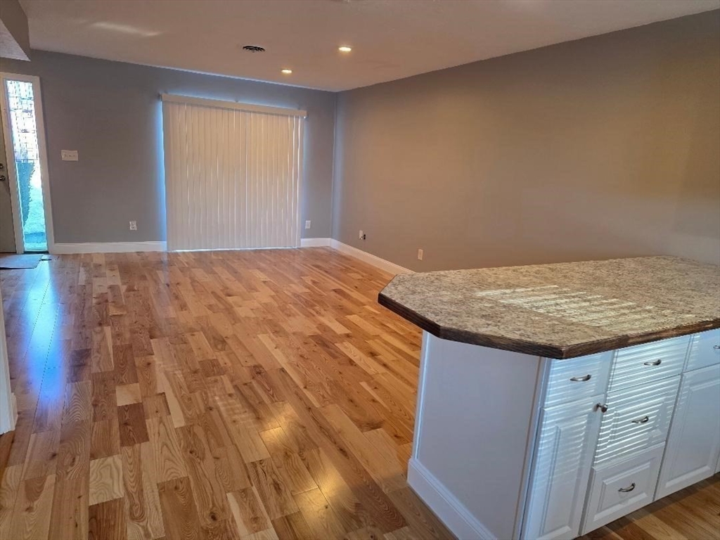 24 Harvard Road, Unit C Ayer, MA 01432 - Photo 2 of 20 a view of wooden floor and cabinet in a room