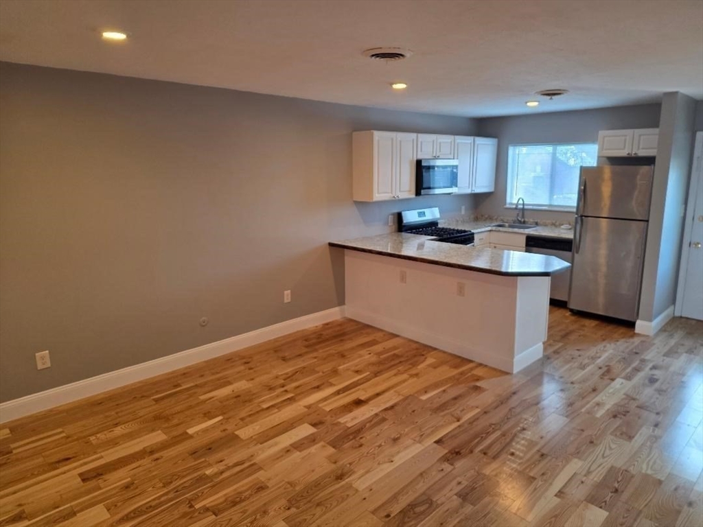 24 Harvard Road, Unit C Ayer, MA 01432 - Photo 8 of 20 a kitchen with stainless steel appliances granite countertop a sink stove and refrigerator