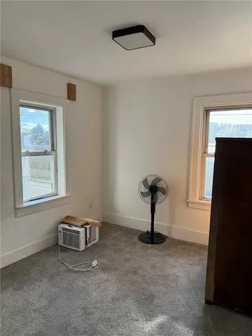 a view of a livingroom with a fireplace and window