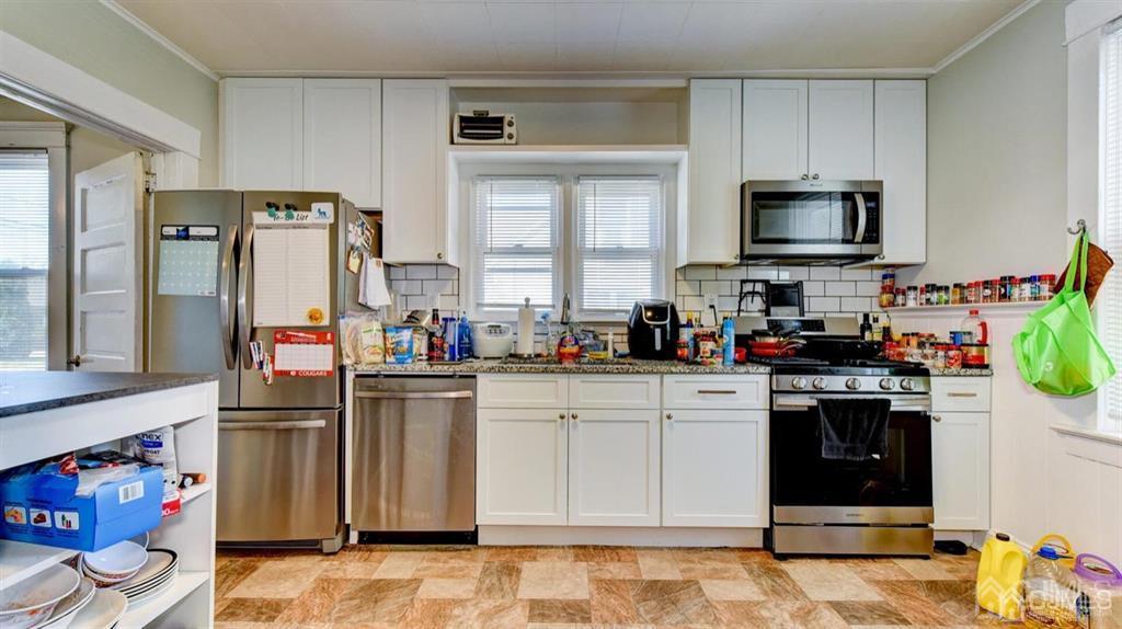 919 Hermann Road North Brunswick, NJ 08902 - Photo 3 of 13 a kitchen with stainless steel appliances granite countertop a refrigerator and a stove top oven