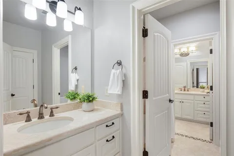 a bathroom with a granite countertop sink a large mirror and a shower