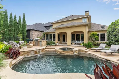 a view of house with swimming pool and outdoor seating