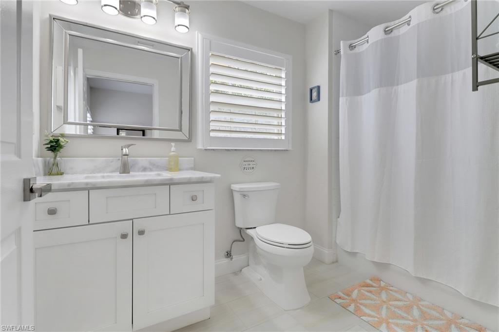 4430 Botanical Pl Circle, Unit 101 Naples, FL 34112 - Photo 12 of 18 a bathroom with a sink toilet and mirror