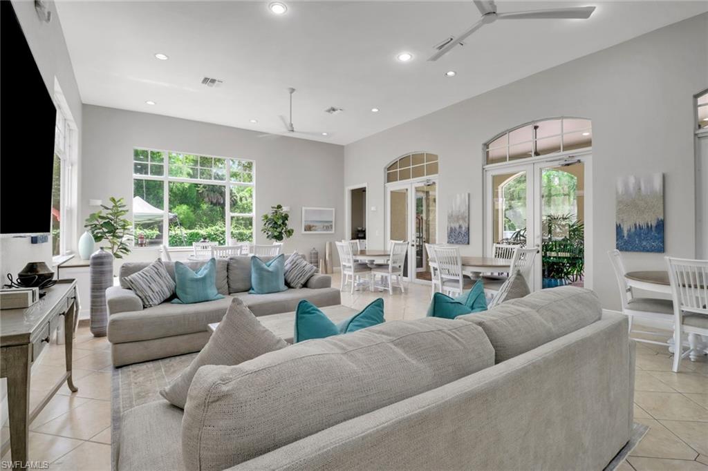 4430 Botanical Pl Circle, Unit 101 Naples, FL 34112 - Photo 16 of 18 a living room with furniture flat screen tv and a large window