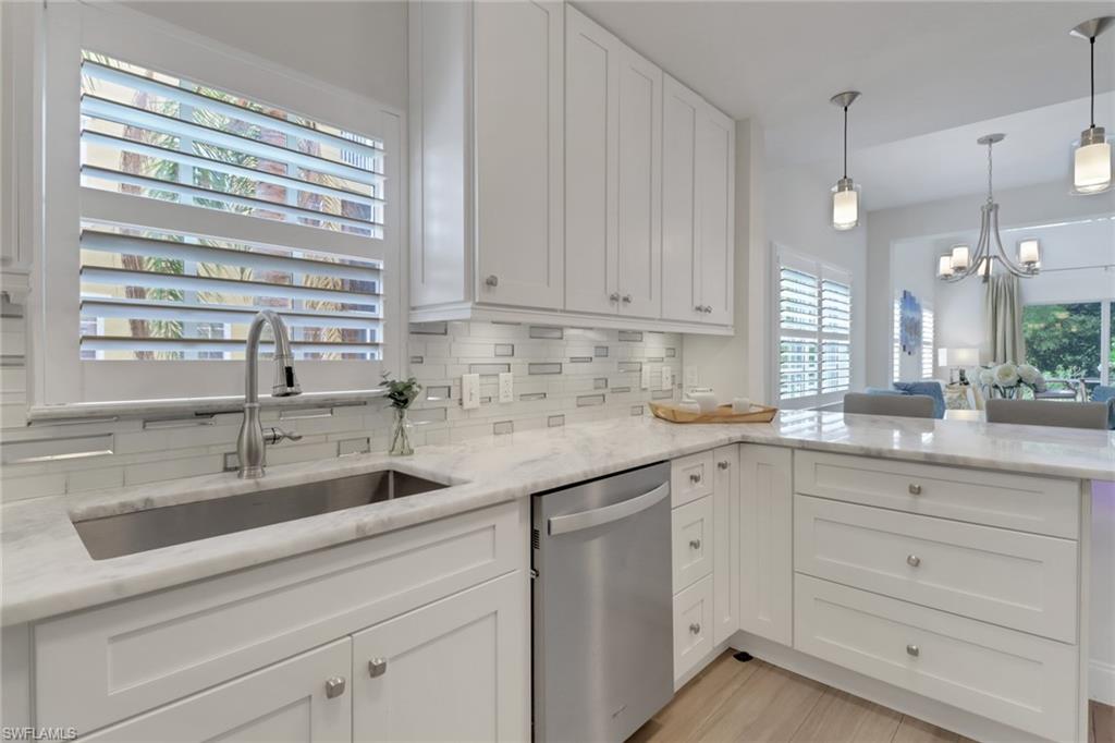 4430 Botanical Pl Circle, Unit 101 Naples, FL 34112 - Photo 2 of 18 a kitchen with cabinets appliances a sink and a window