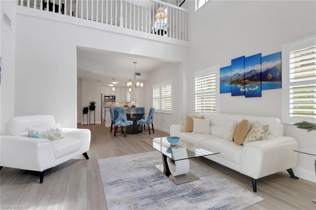 4430 Botanical Pl Circle, Unit 101 Naples, FL 34112 - Photo 5 of 18 a living room with furniture and a potted plant on table