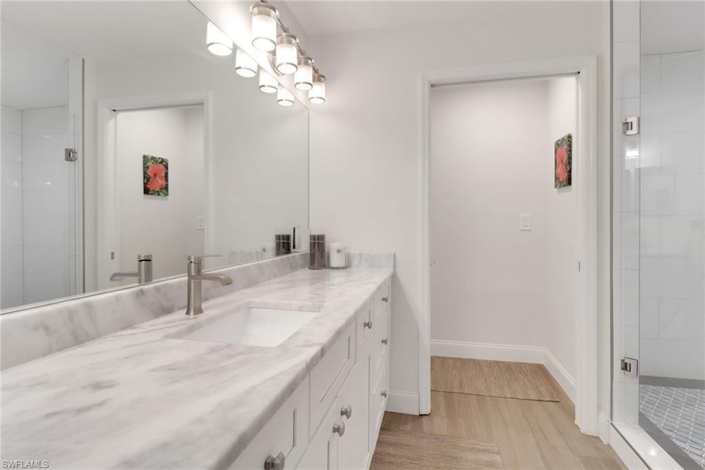 4430 Botanical Pl Circle, Unit 101 Naples, FL 34112 - Photo 7 of 18 a bathroom with a double vanity sink and a mirror