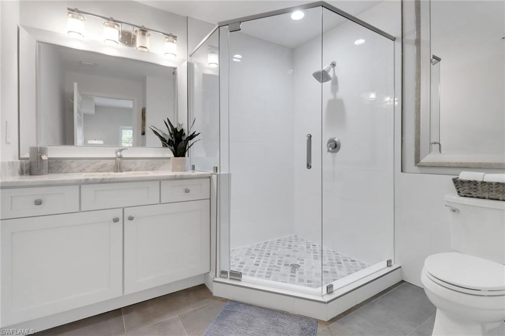 4430 Botanical Pl Circle, Unit 101 Naples, FL 34112 - Photo 10 of 18 a bathroom with a shower a mirror and a sink