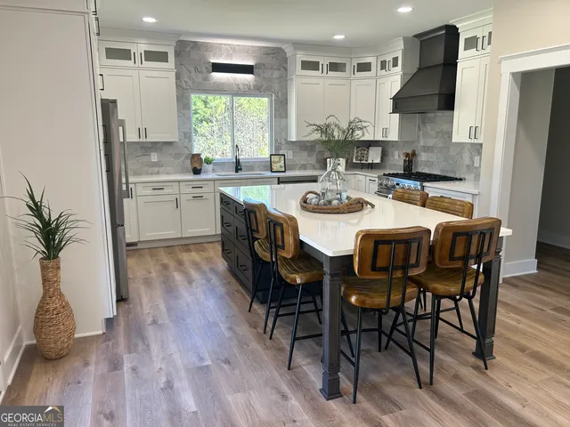 a kitchen with granite countertop a sink stove and refrigerator