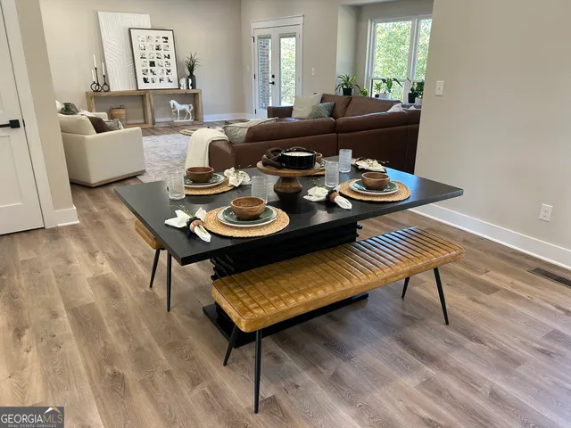 a view of an empty room with windows and chandelier fan