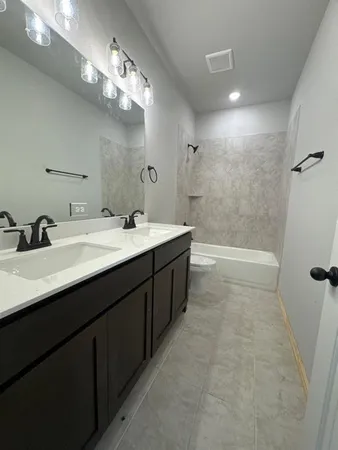 a spacious bathroom with a double vanity sink a mirror and a bathtub