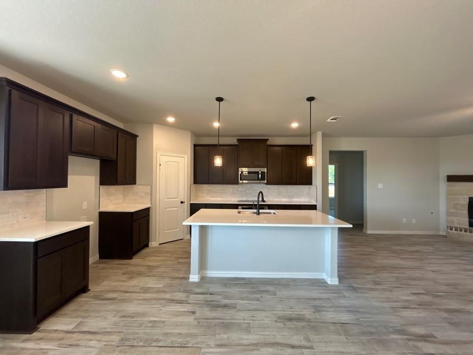 8779 County Road 623 Blue Ridge, TX 75424 - Photo 5 of 14 Kitchen featuring dark wood-finish cabinetry, light countertops, and a subway tile backsplash