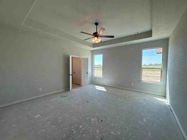 an empty room with windows and fan
